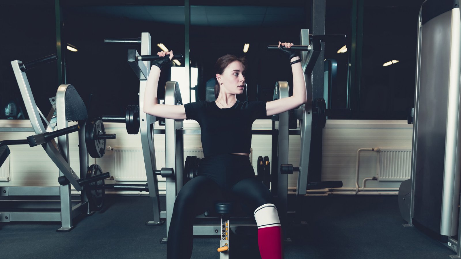 young-woman-exercising-shoulder-press-machine